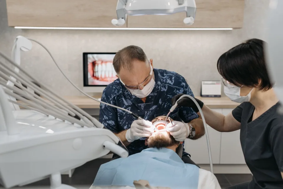 Dentist and assistant performing a dental procedure on a patient in a modern clinic.