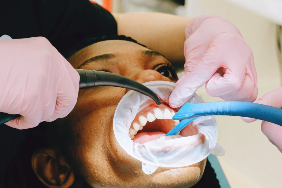 Close-up of a dental professional performing a checkup on a patient in a clinic setting.